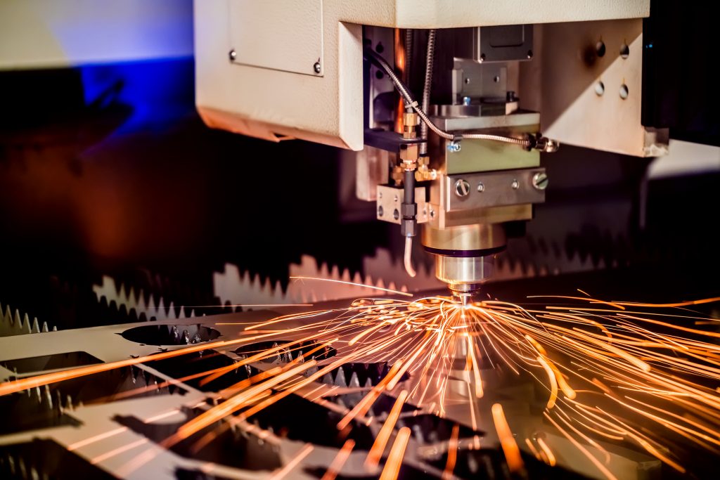 CNC Laser cutting of metal, modern industrial technology. Small depth of field. Warning - authentic shooting in challenging conditions. A little bit grain and maybe blurred.